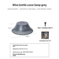 Beige and grey camping lantern with wine bottle-shaped shade showing USB-C port and light modes.