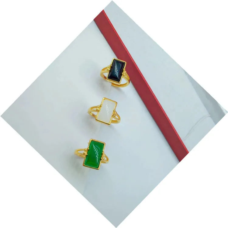 Adjustable brass gold-plated ring with an electroplated finish and a choice of black, green, or white gemstone.
