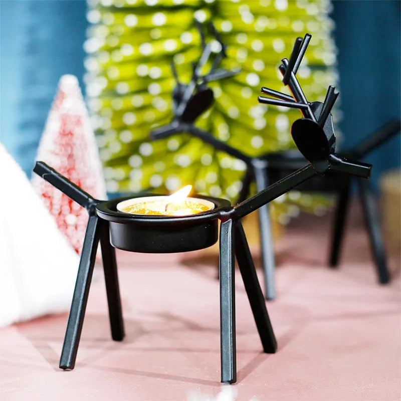 Black iron elk Christmas candlestick holder on table with candle
