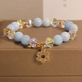 Women's aquamarine crystal bracelet with four-leaf clover charm and pearl accents in light luxury design
