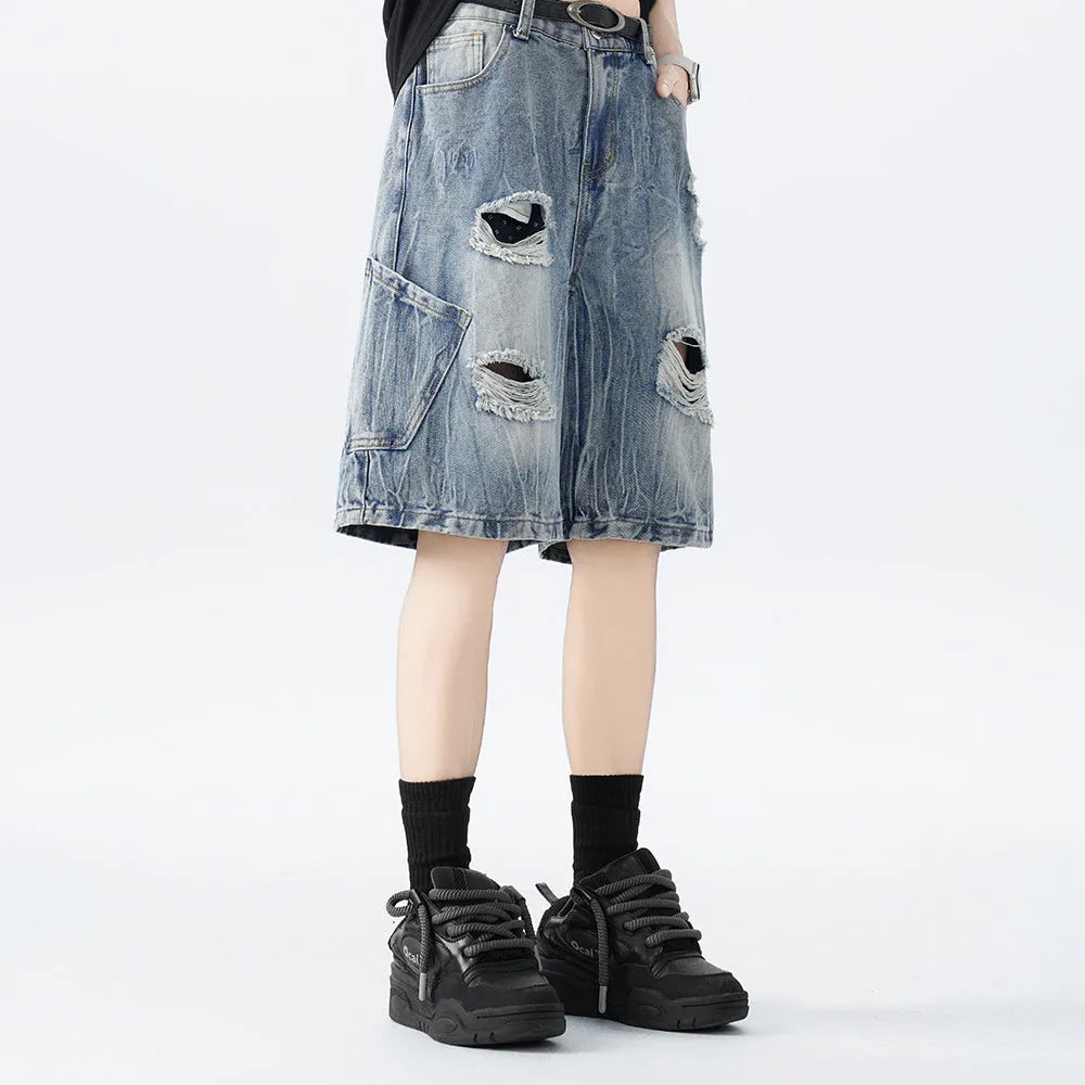 Washed black denim shorts with ripped details and a loose retro fit.
