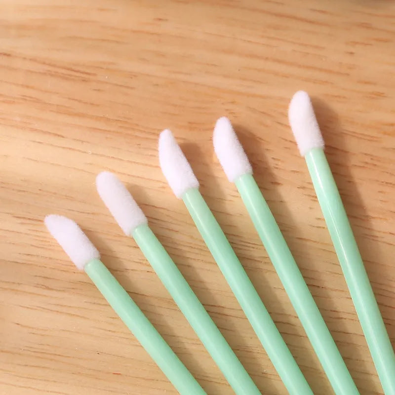 Disposable lip brushes with black handles and flocked tips in bulk packaging for lipstick and gloss application