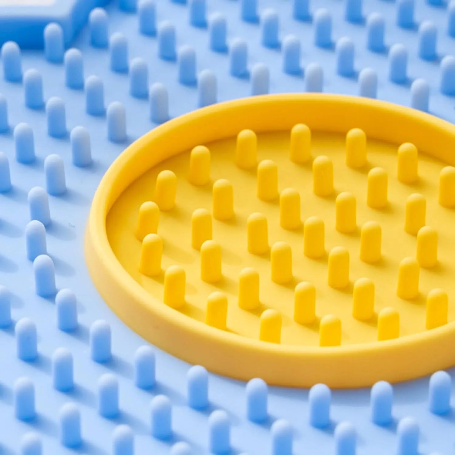 Flower-shaped blue silicone pet lick mat with suction cups on a smooth surface