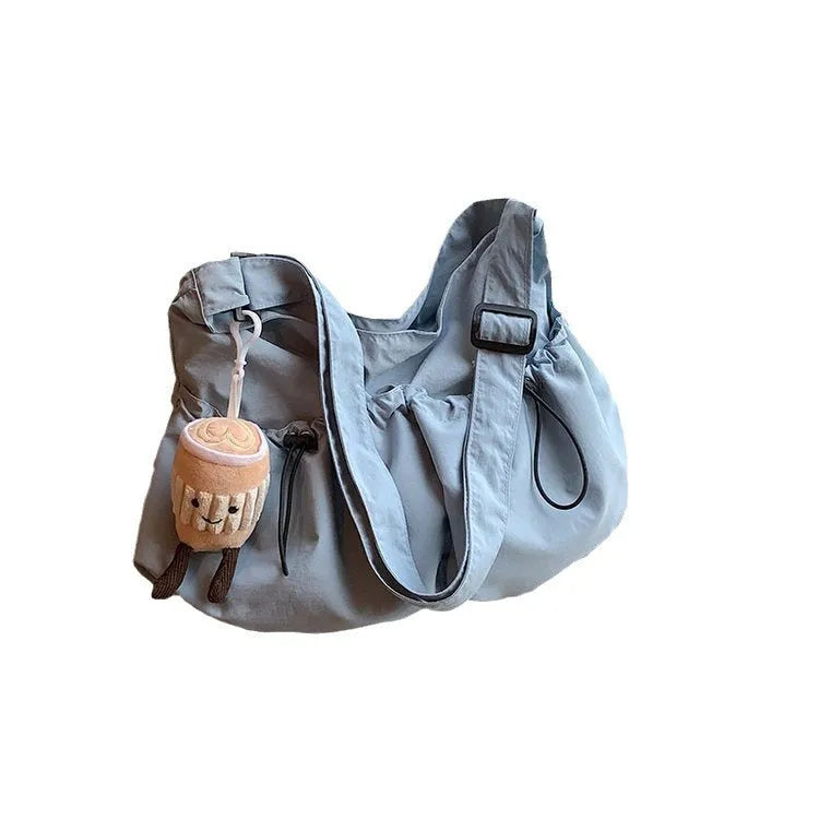 Green pleated foldable polyester crossbody bag showing split pocket and internal phone compartment.