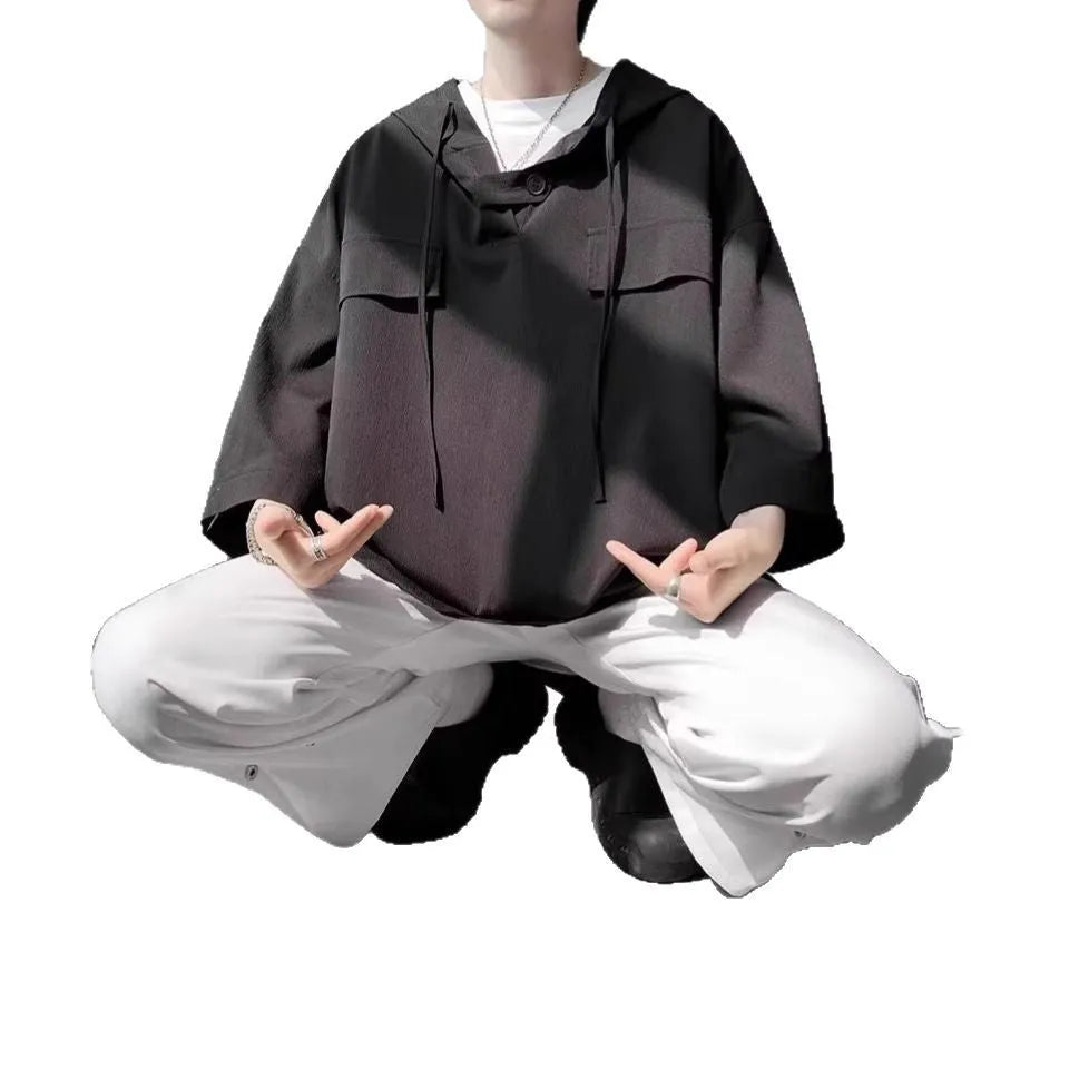 Man wearing a loose fit black hooded short sleeve t-shirt for summer.