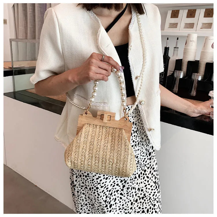 Women's soft straw woven horizontal square shoulder bag with pearl chain strap in beige colour.
