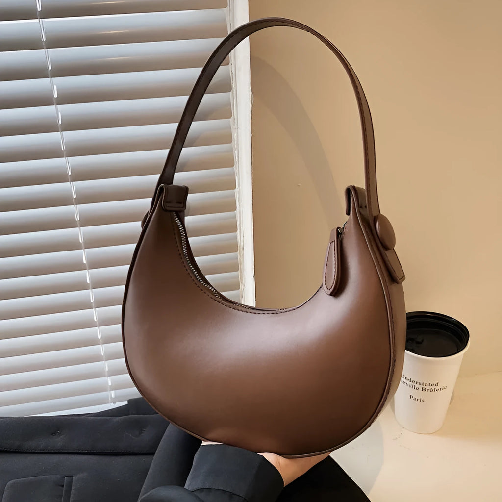 Women's retro-style dumpling-shaped PU leather shoulder bag in cream yellow, showing sandwich pocket.