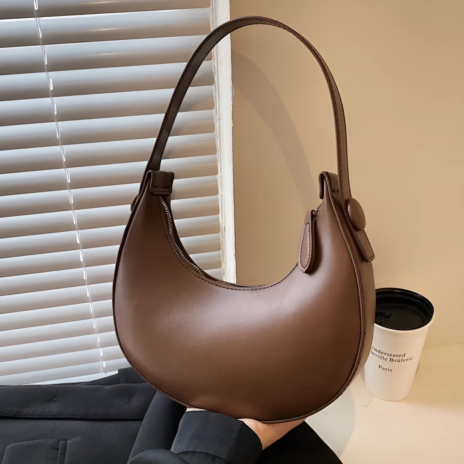 Women's retro-style dumpling-shaped PU leather shoulder bag in cream yellow, showing sandwich pocket.