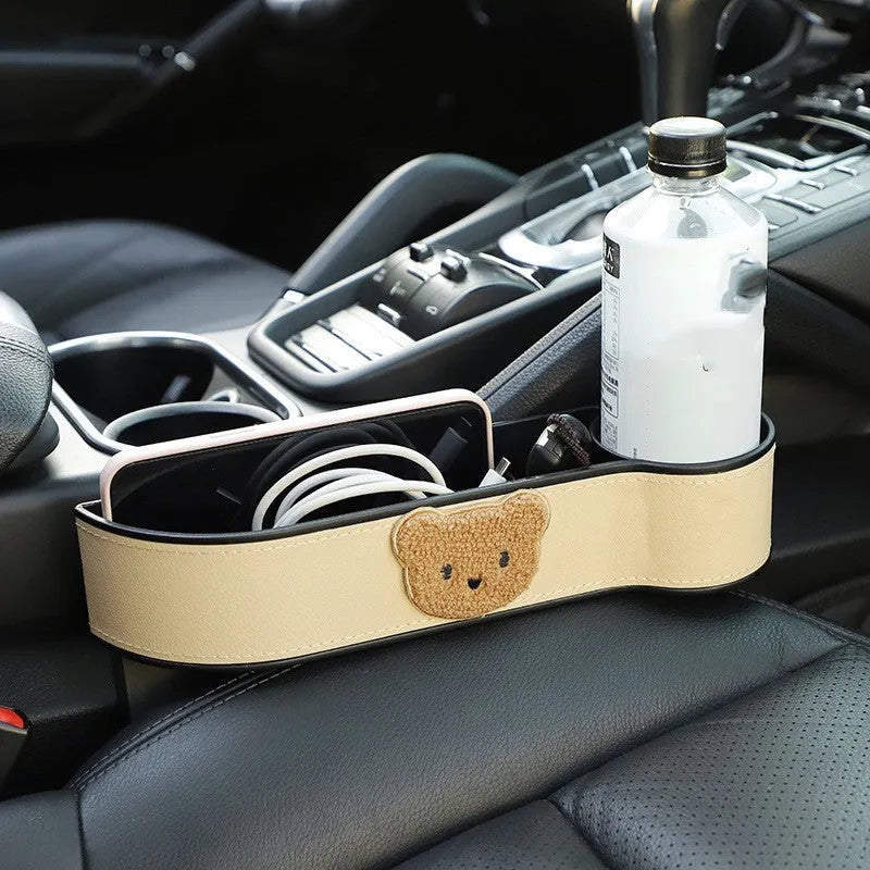 Leather car seat gap storage box with cartoon bear design for organising phones and keys.