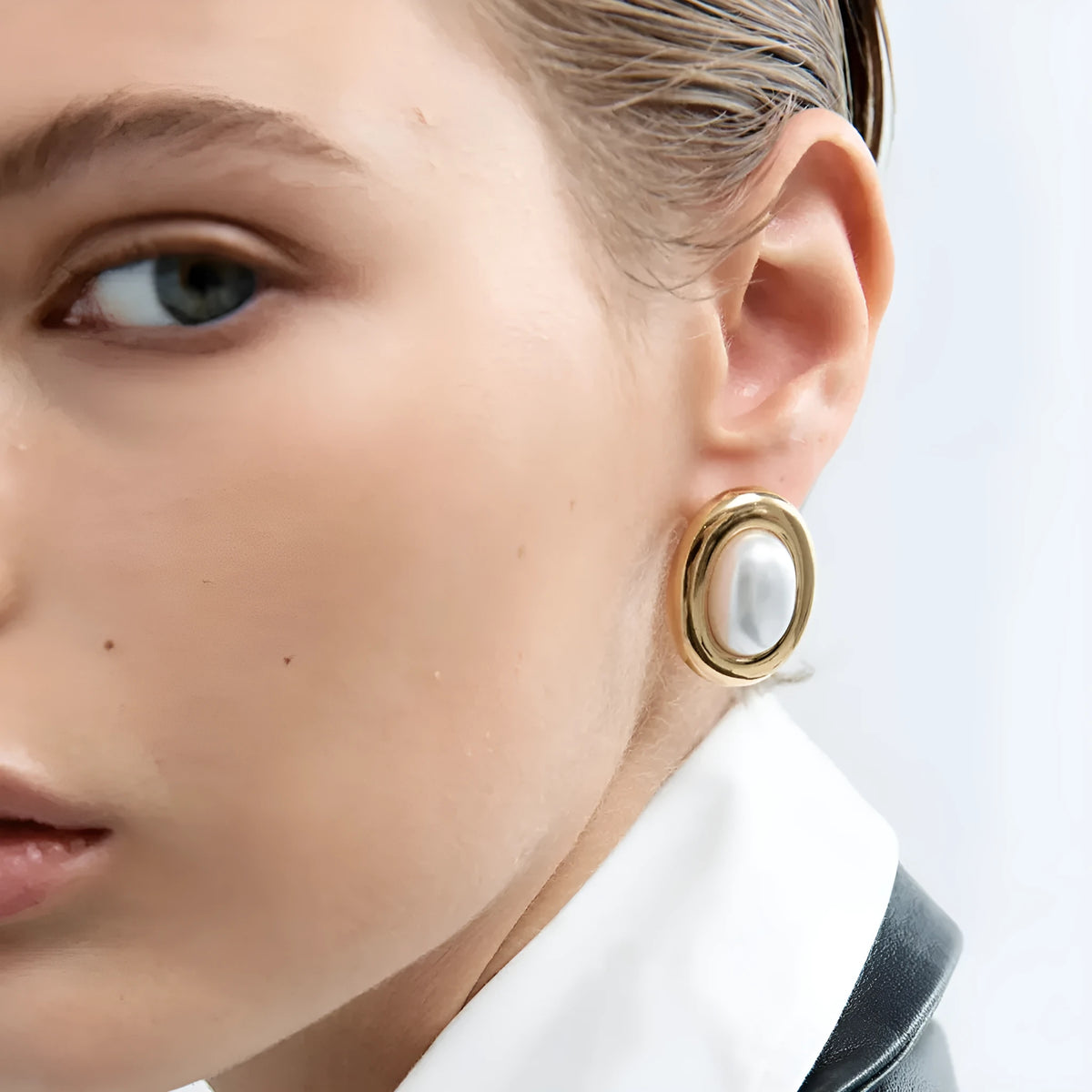 A pair of women's stainless steel stud earrings with a vintage-style pearl and electroplated finish.