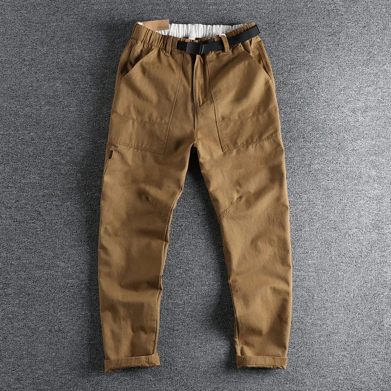 Men's khaki cotton work trousers with mid waist and zipper fly on a neutral background