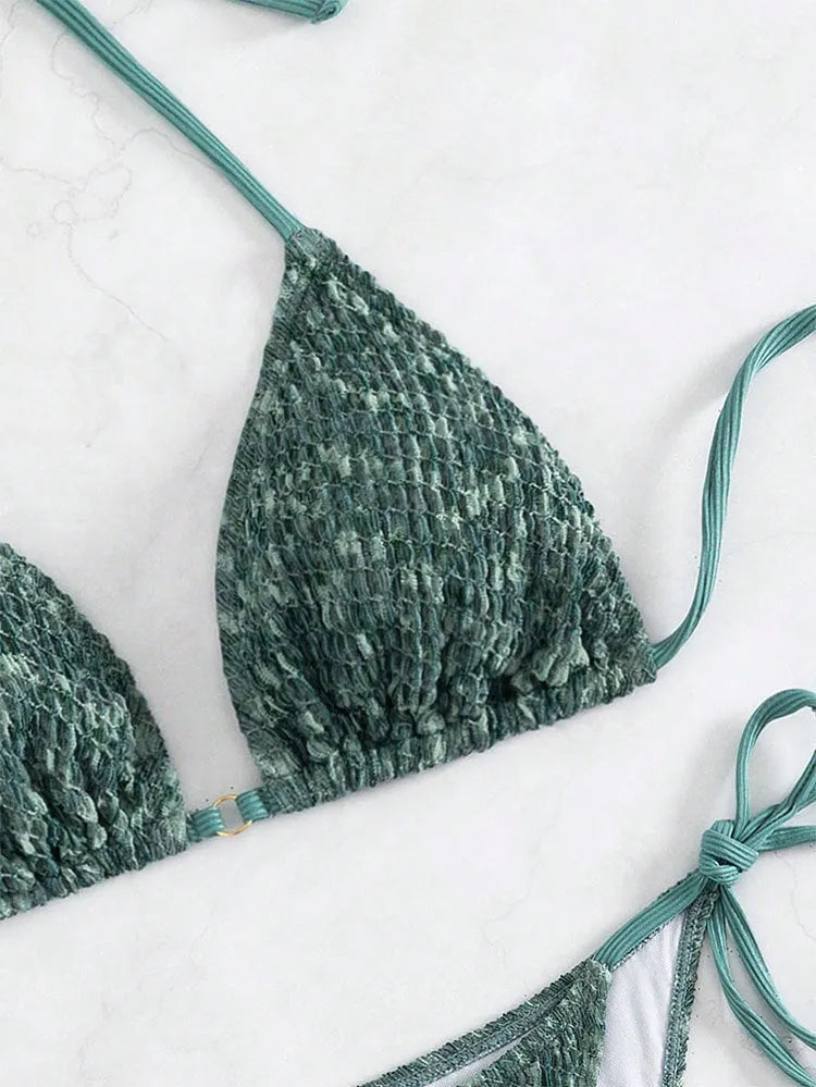 Green women's backless halter strap bikini set with matching shorts on a mannequin.