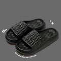 Pair of grey EVA foam slippers with leaf texture pattern and non-slip sole.