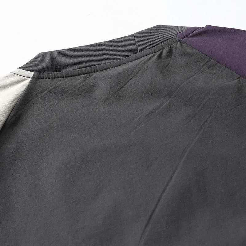 Dark grey loose fit T-shirt with contrast colour raglan sleeves on a hanger.