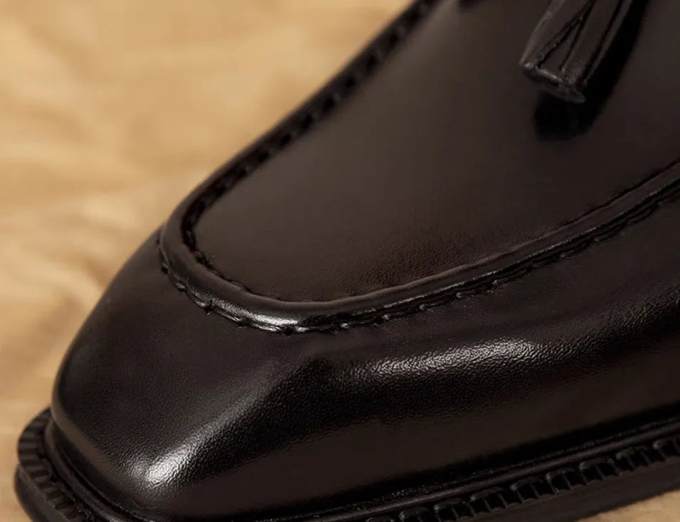 Men's black genuine leather loafers with fringed detail, rubber sole, and slip-on design