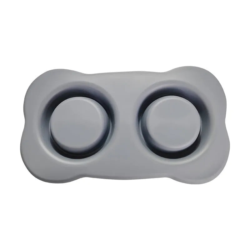 Large black silicone dog bowl sitting inside a stainless steel base, shown on a kitchen floor.