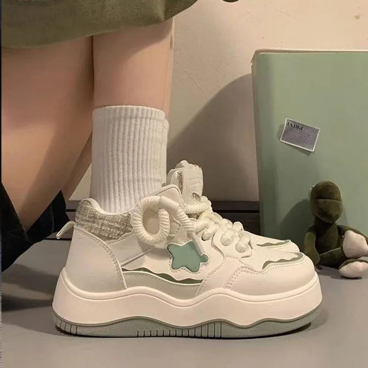 Women's green platform sneakers with round toe and lace-up design on a white background.