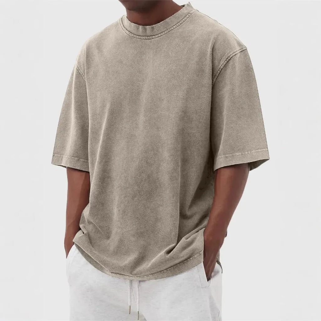 Man wearing a loose-fit stone washed solid colour t-shirt in a casual setting.
