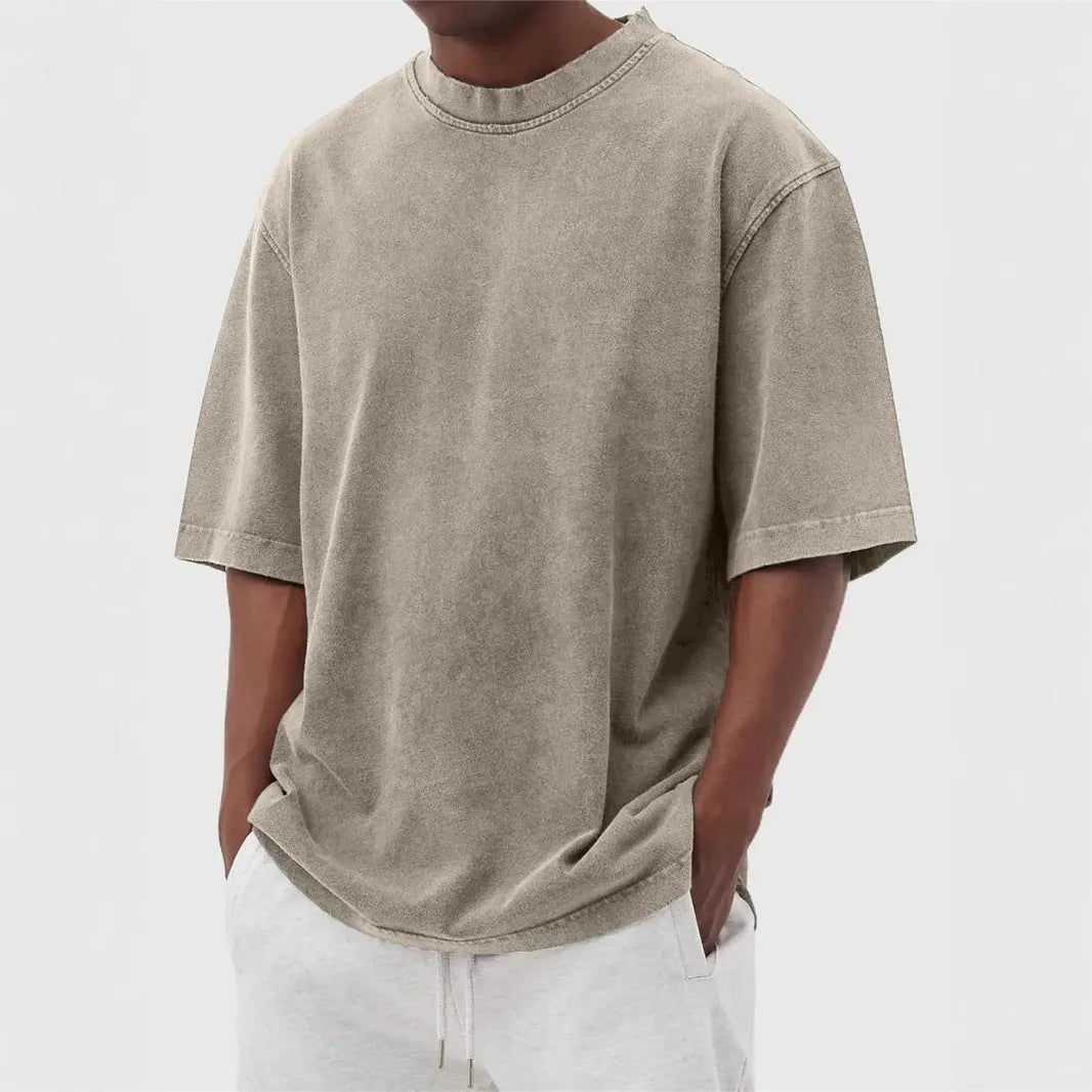 Man wearing a loose-fit stone washed solid colour t-shirt in a casual setting.