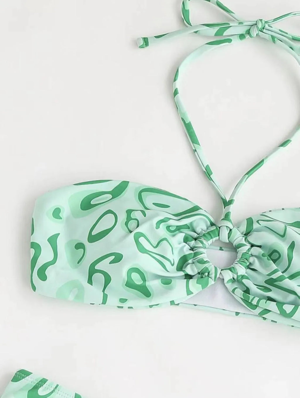 Women's blue floral bandeau bikini swimsuit with split design on beach background