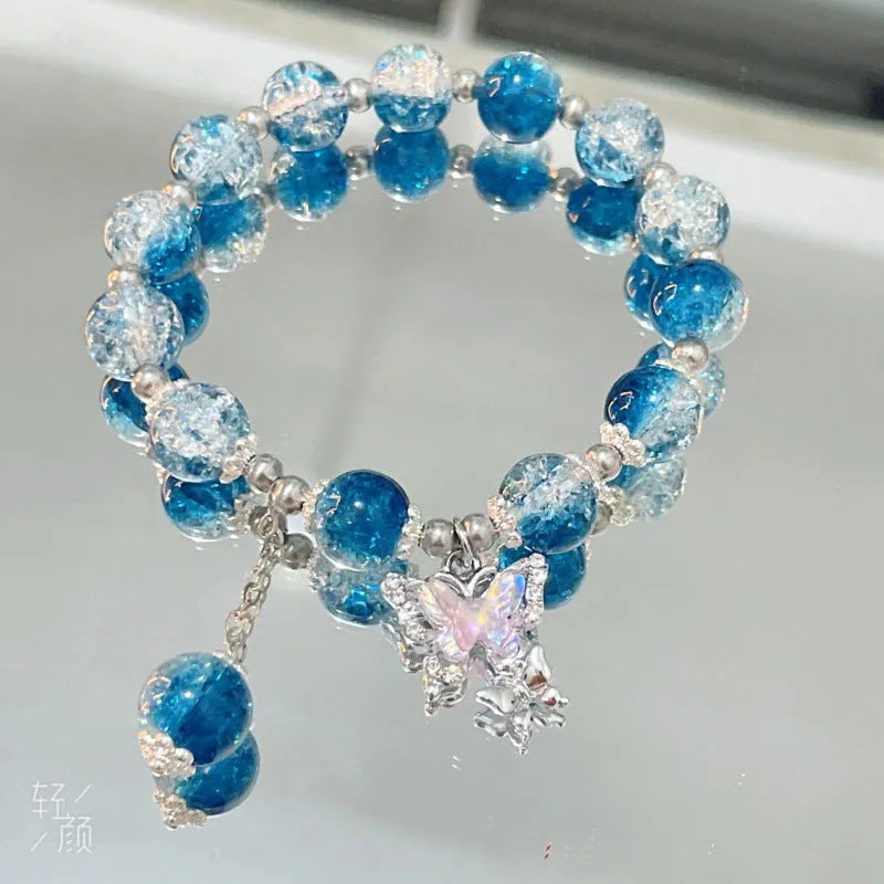 A Chinese style glass bracelet with bamboo leaf and bead designs on a wrist.