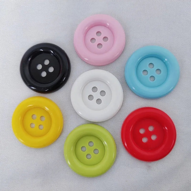 Assortment of oversized round plastic buttons in multiple colours showing four-hole design