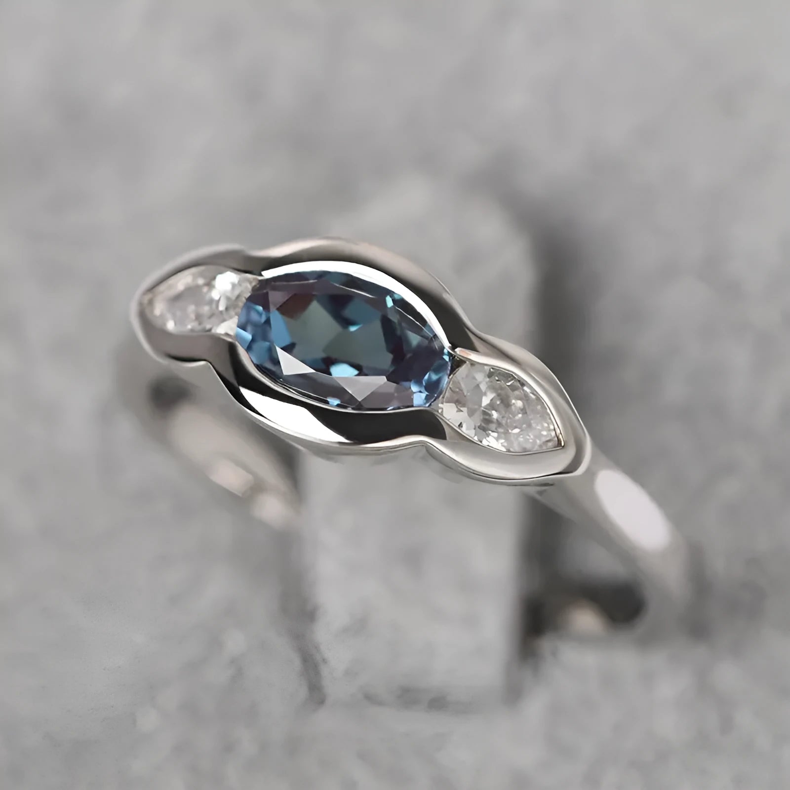 Geometric ellipse ring with inlaid zircon stones in white gold colour on female hand