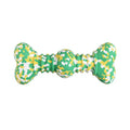 Green and white camouflage patterned natural rubber bone-shaped dog chew toy for large dogs on a wooden floor.