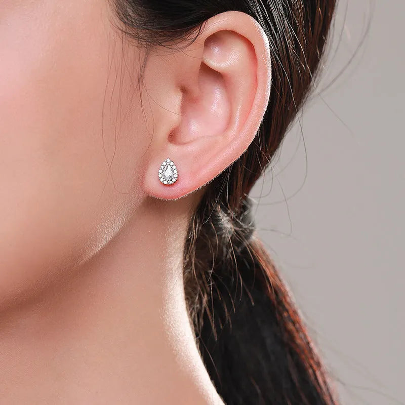 Close-up of women's sterling silver water drop shaped ear studs with diamond cut facets on a white background.