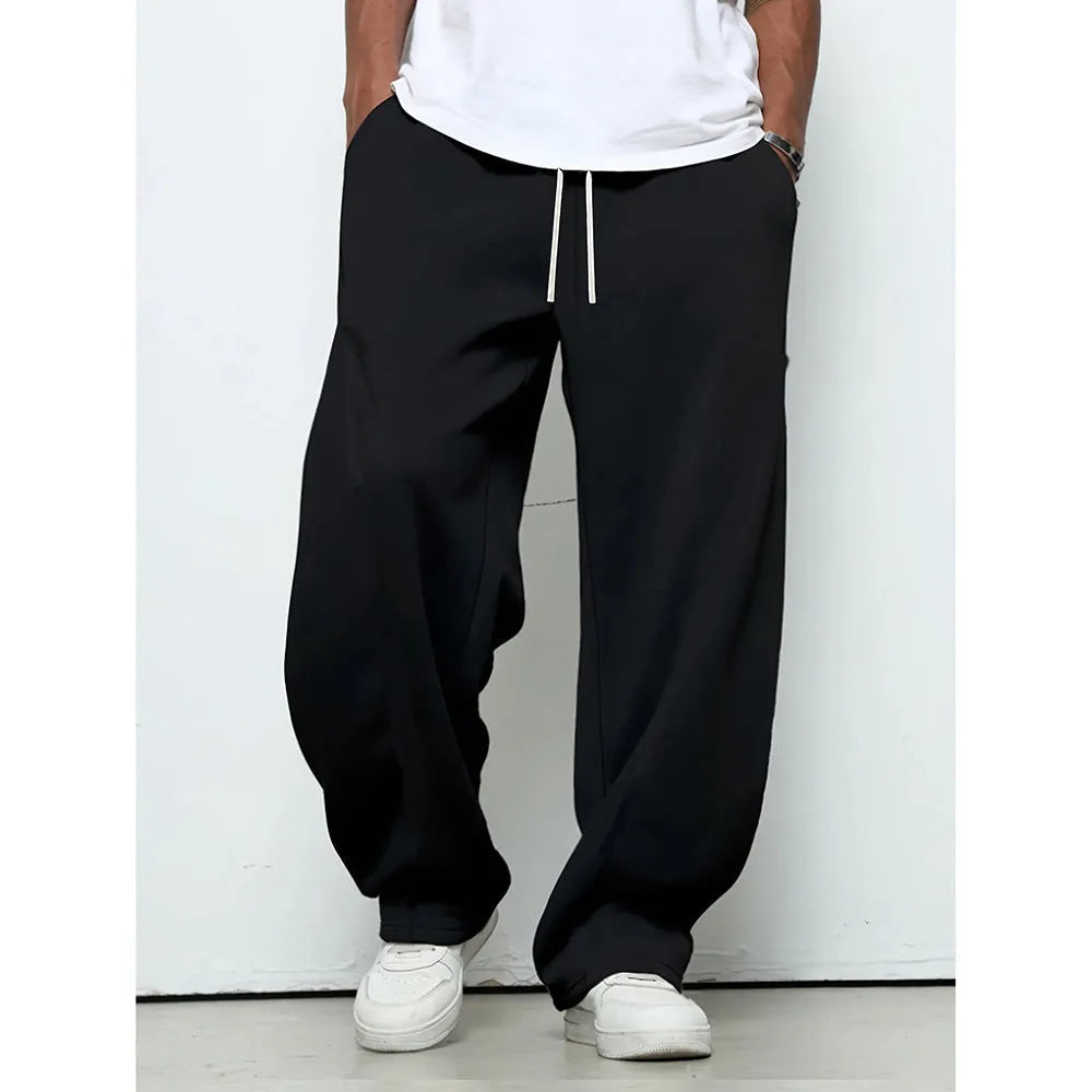 Men's straight-leg casual trousers in black with a drawstring waist, shown flat.