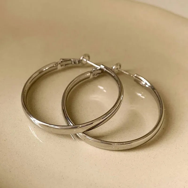 Pair of 40mm diameter circular metal earrings with gold electroplated finish
