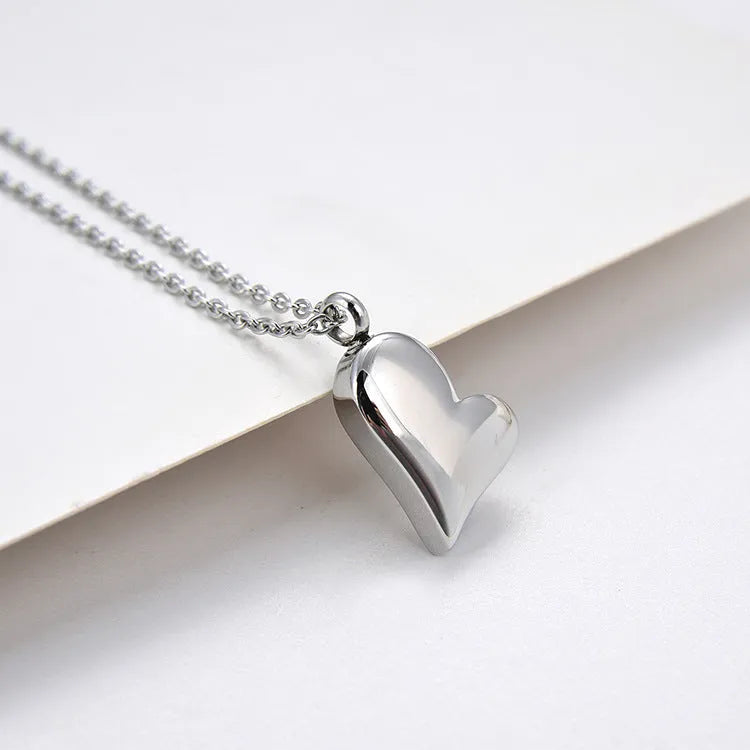 Silver curved peach heart pendant on stainless steel chain with extension
