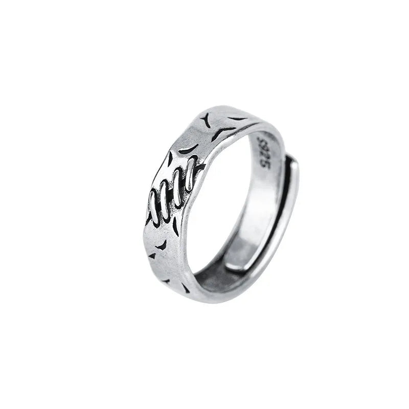 Black copper geometric ring with adjustable opening and round oval design elements.