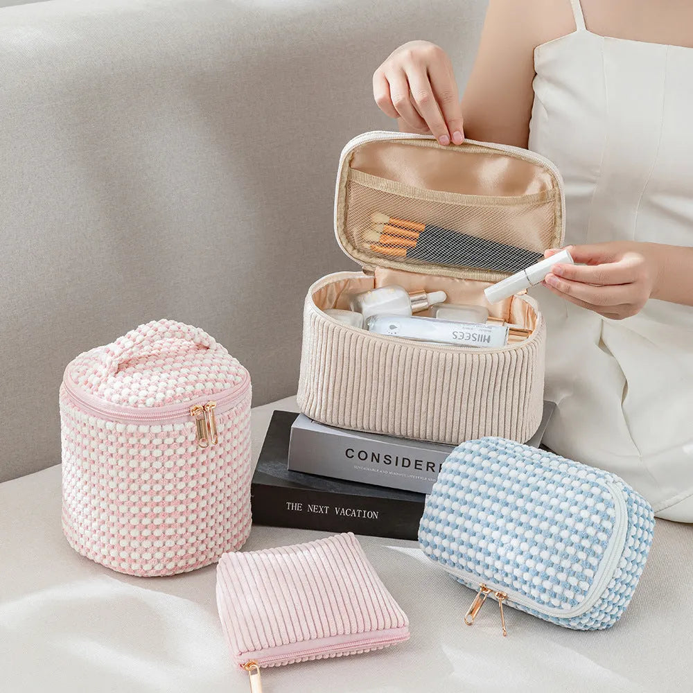Four cube-shaped flannelette makeup bags in different colours including pink, khaki, pink dots, and blue with dots
