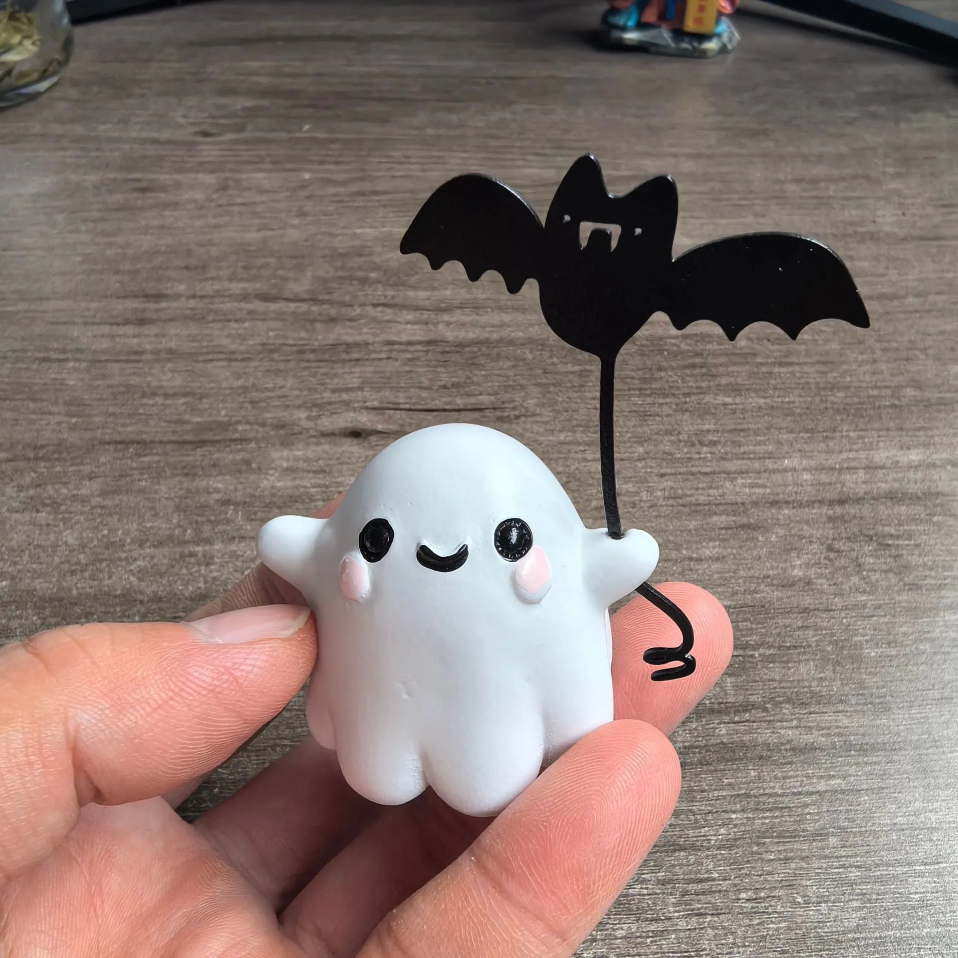 Small resin statue of a ghost dog with a bat, a miniature Halloween ornament.