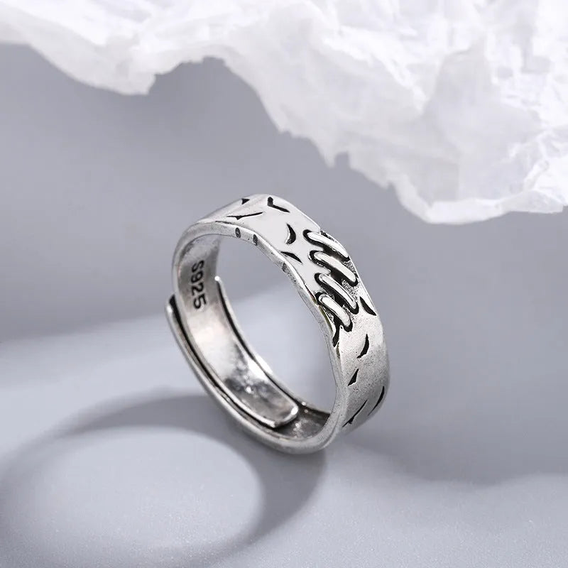 Black copper geometric ring with adjustable opening and round oval design elements.