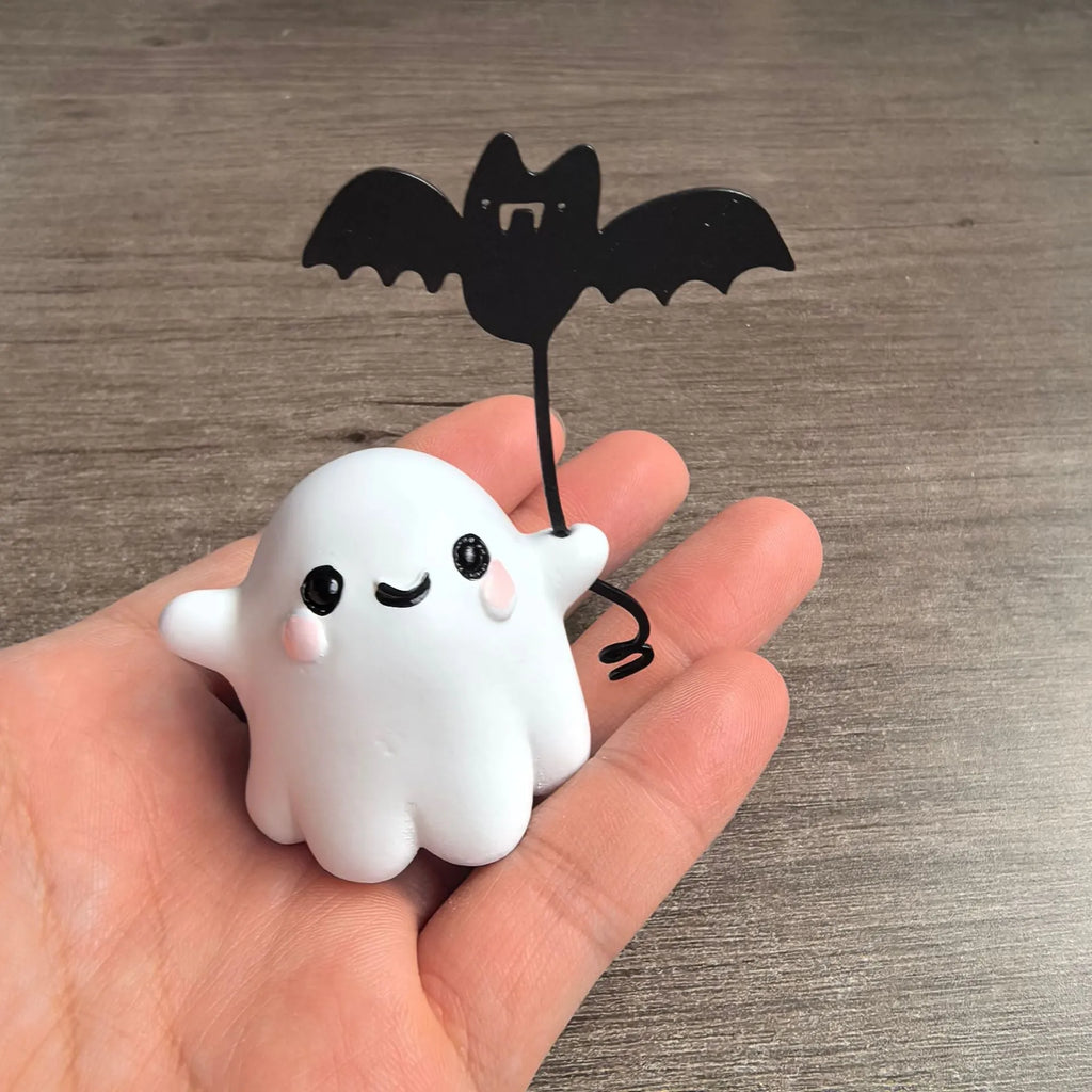 Small resin statue of a ghost dog with a bat, a miniature Halloween ornament.