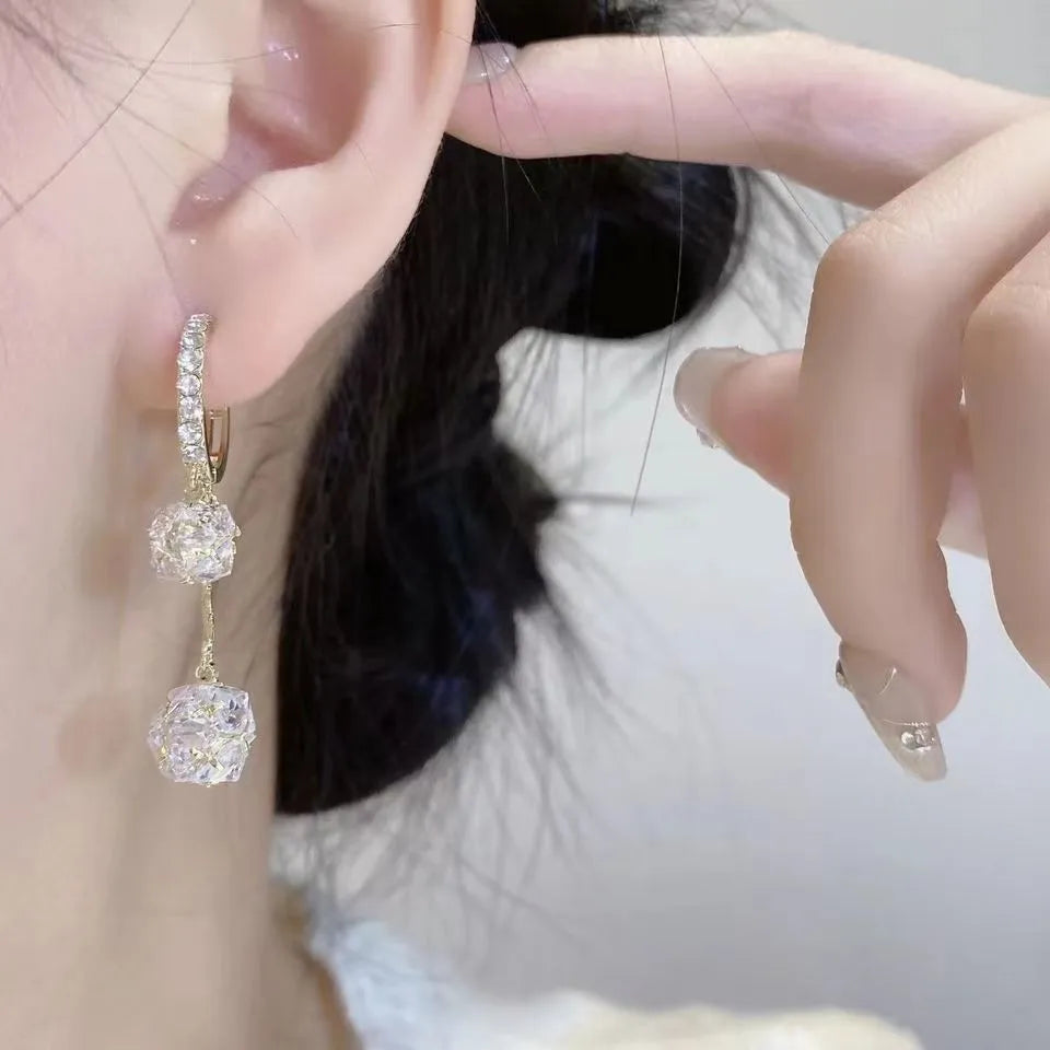Women's silver-toned drop earrings with a double pendant and rhinestone ball tassel on an ear clip.