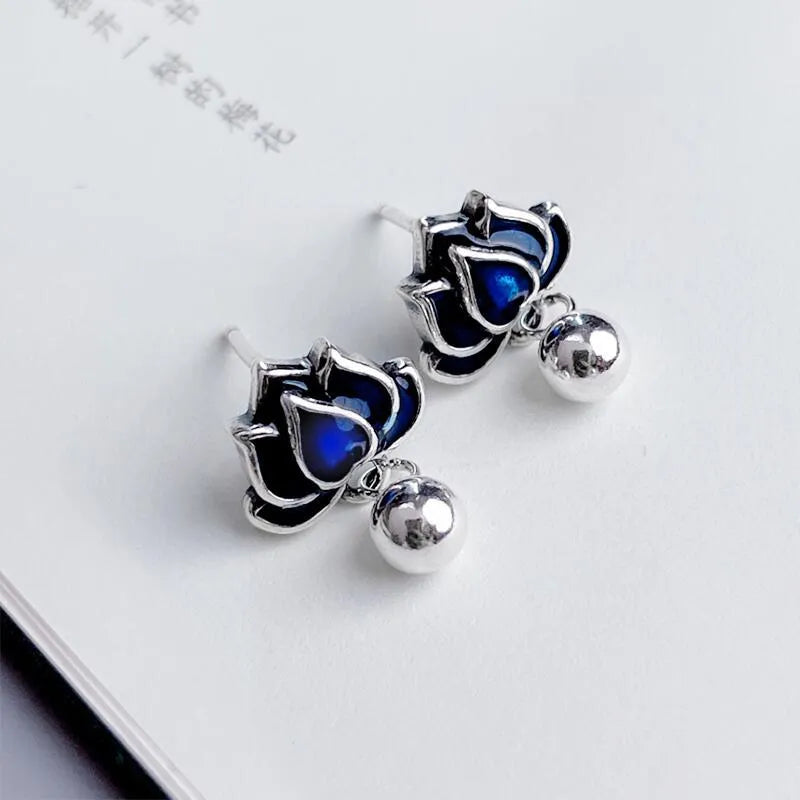 Blue Lotus earrings with a flower stud and dangling seedpod tassel in silver-tone alloy.