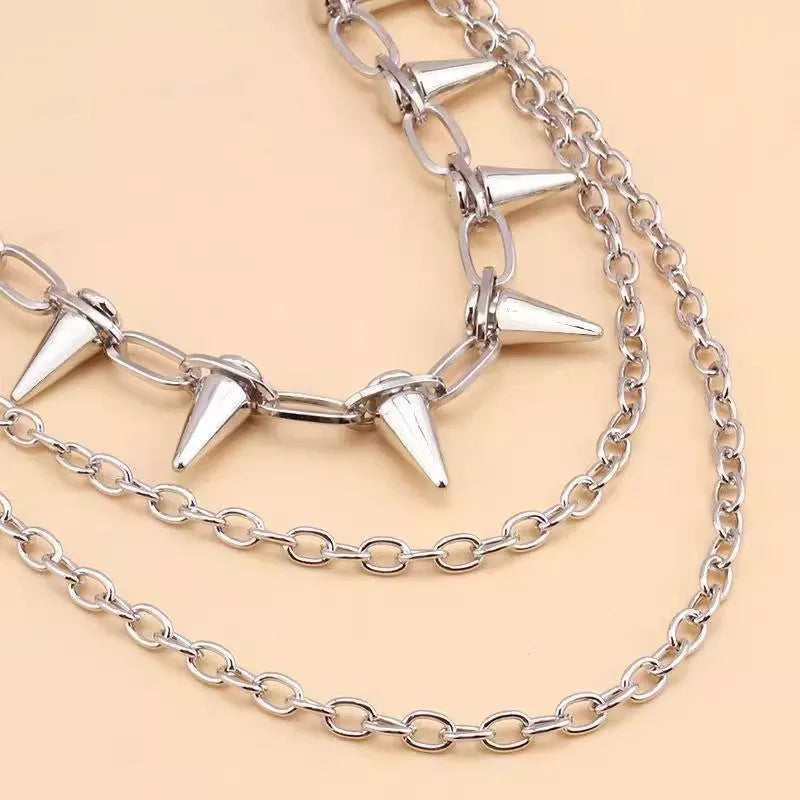Silver punk pants chain with double layers, zipper detail, and rivet accents against dark background