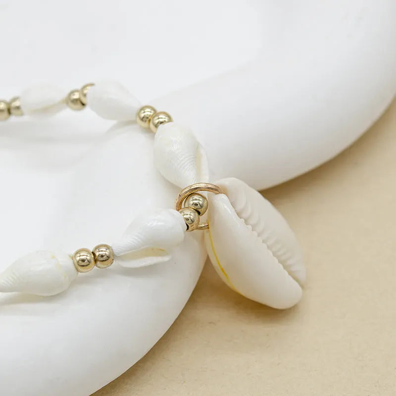 White necklace with a conch shell pendant made from Mother Pearl shellfish on an electroplated chain.
