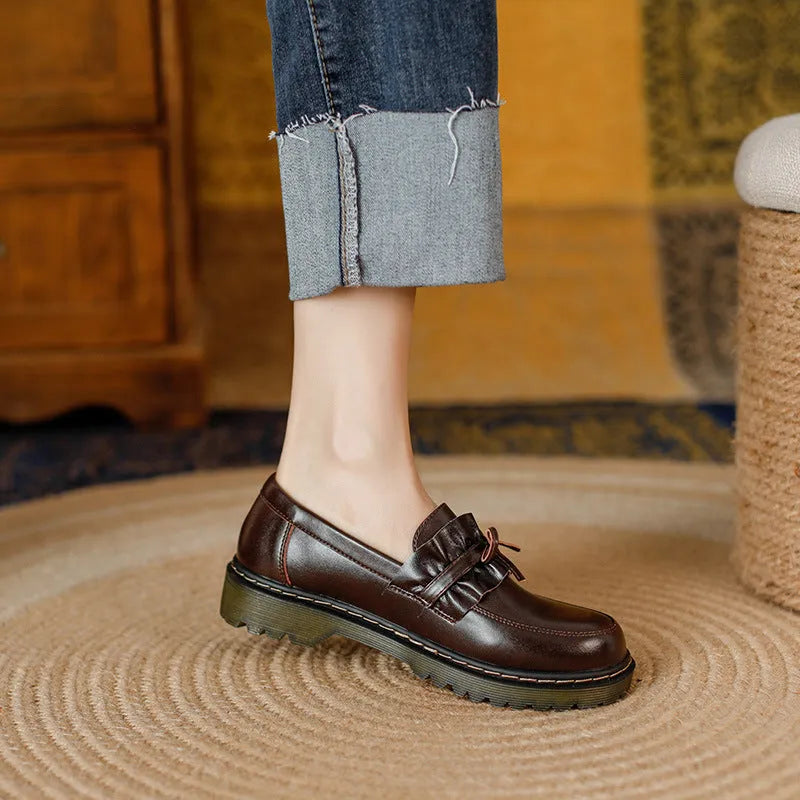 Black and brown women's round toe leather boots with chunky flat heels on display