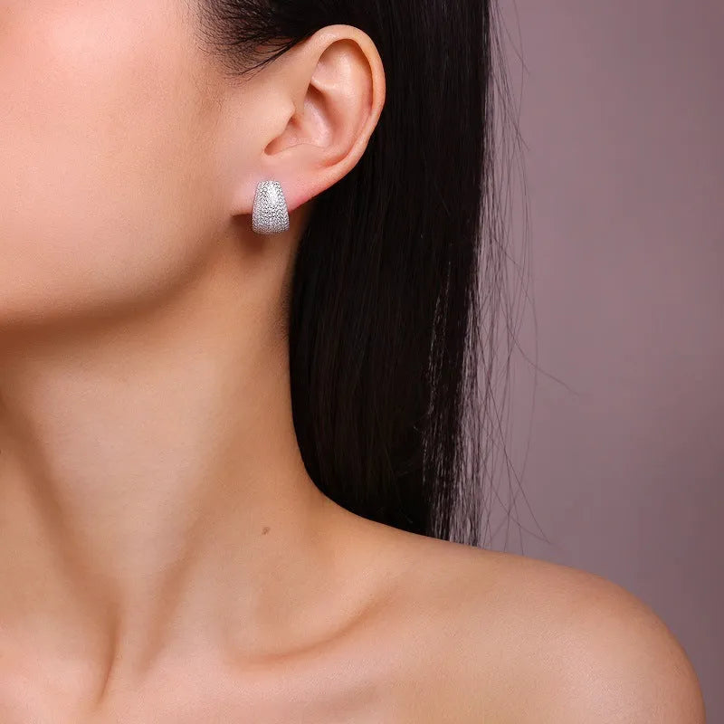 Geometric shaped sterling silver stud earrings with a white moissanite stone.