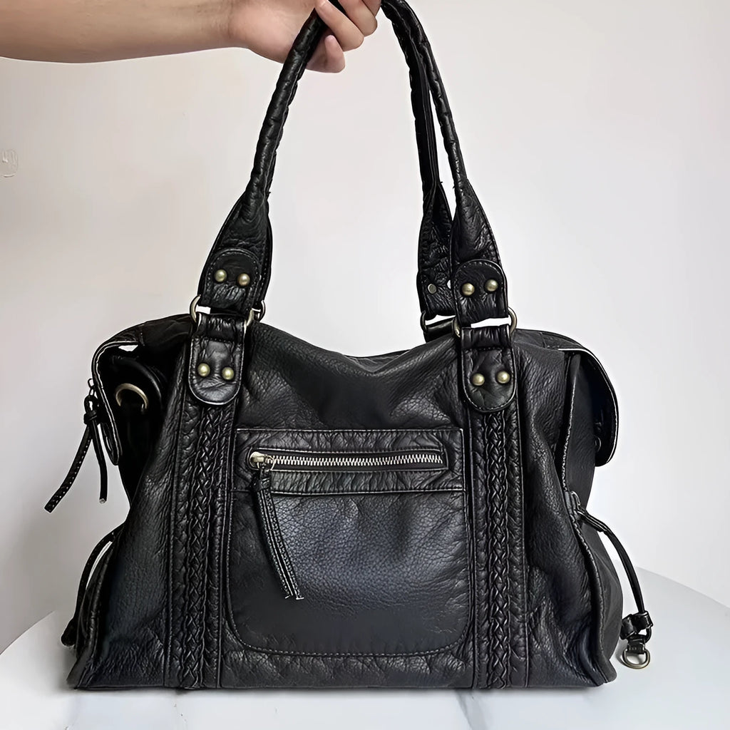 Women's brown soft PU French retro motorcycle shoulder messenger bag with woven design on a table.