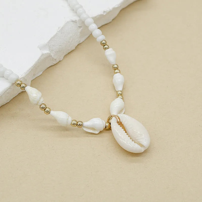 White necklace with a conch shell pendant made from Mother Pearl shellfish on an electroplated chain.
