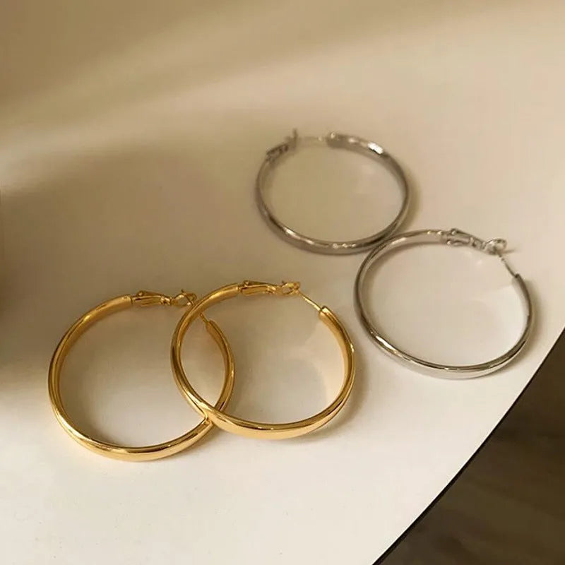 Pair of 40mm diameter circular metal earrings with gold electroplated finish