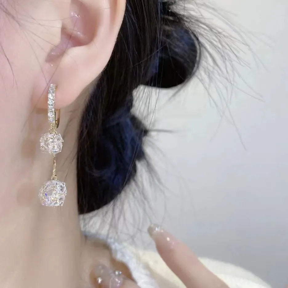 Women's silver-toned drop earrings with a double pendant and rhinestone ball tassel on an ear clip.