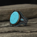 Men's round turquoise ring in antique silver alloy showing simple design and stone setting