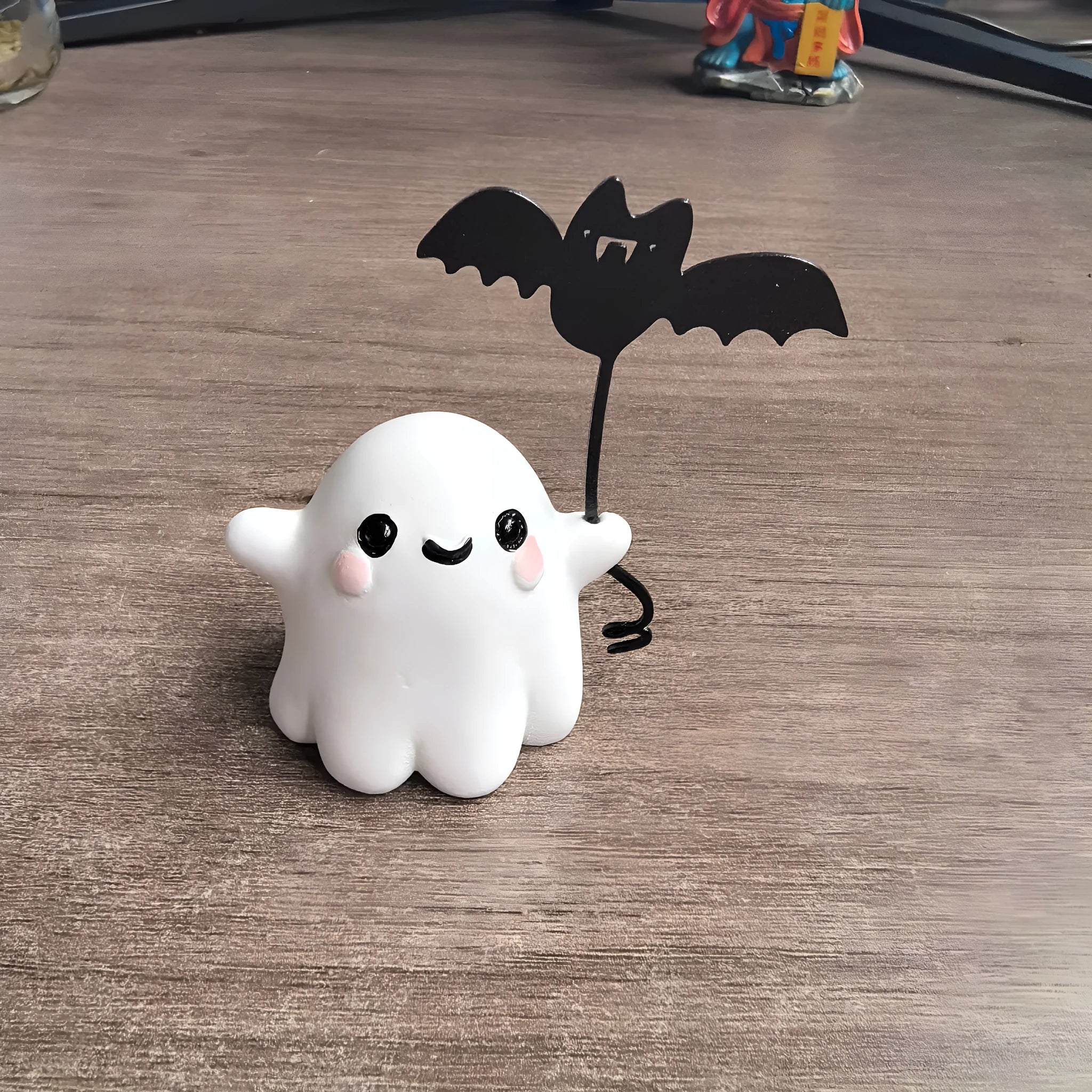 Small resin statue of a ghost dog with a bat, a miniature Halloween ornament.