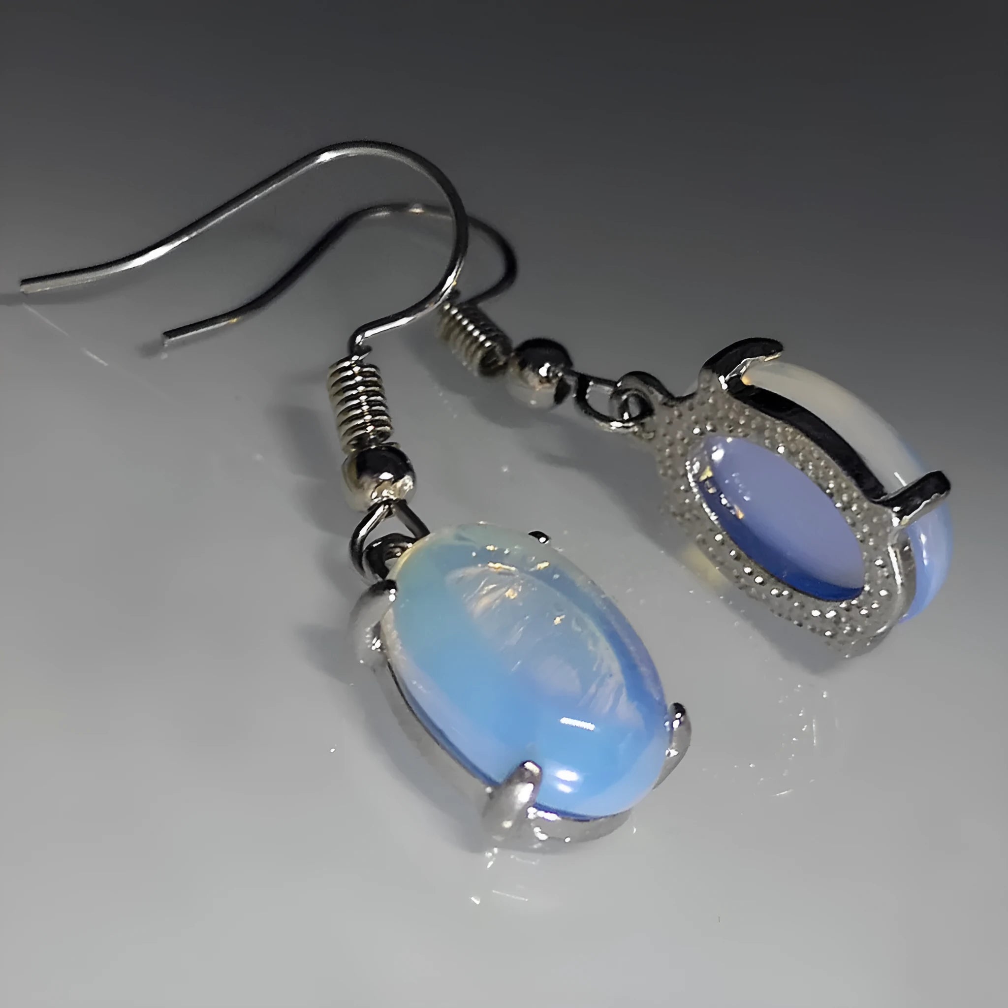 Moonlight white opal earrings with cross shaped drop design and retro moonstone appearance